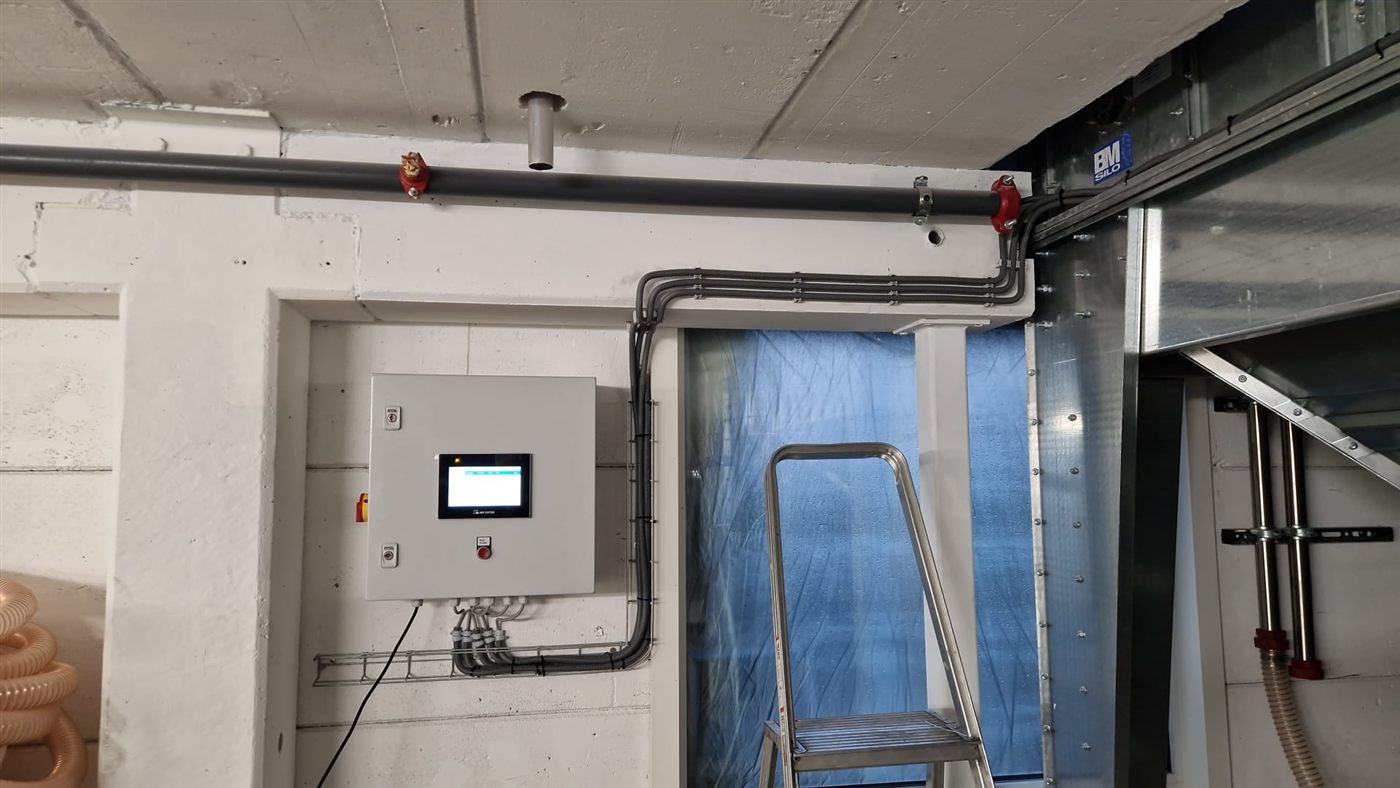 Kompakter Schaltschrank mit Touchscreen für die Silomessung, vor Ort neben den Materialleitungen einer Siloanlage montiert